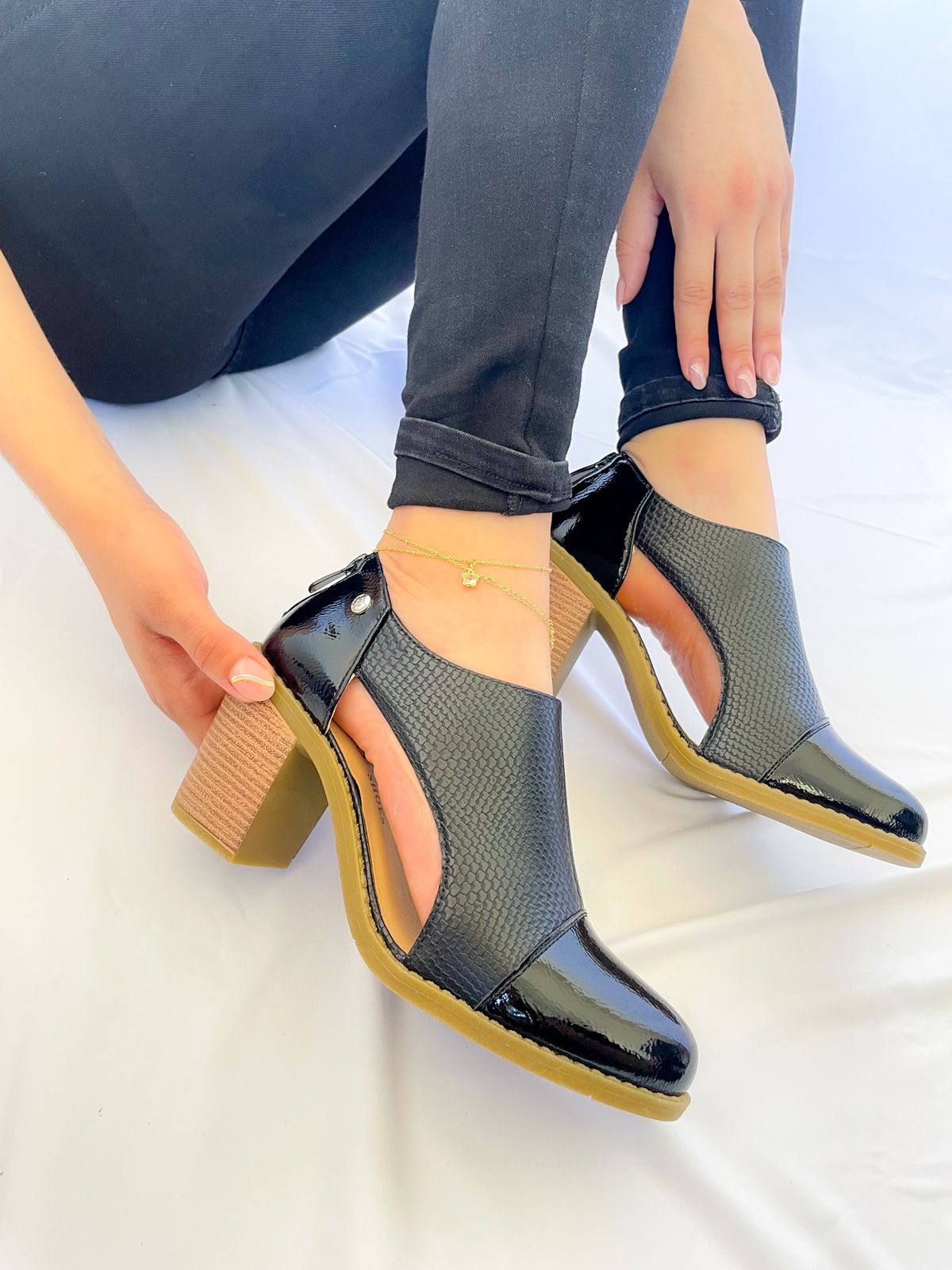 Botín negro con textura en ecocuero, corte moderno y cierre trasero, ideal para caminar cómoda todo el día.