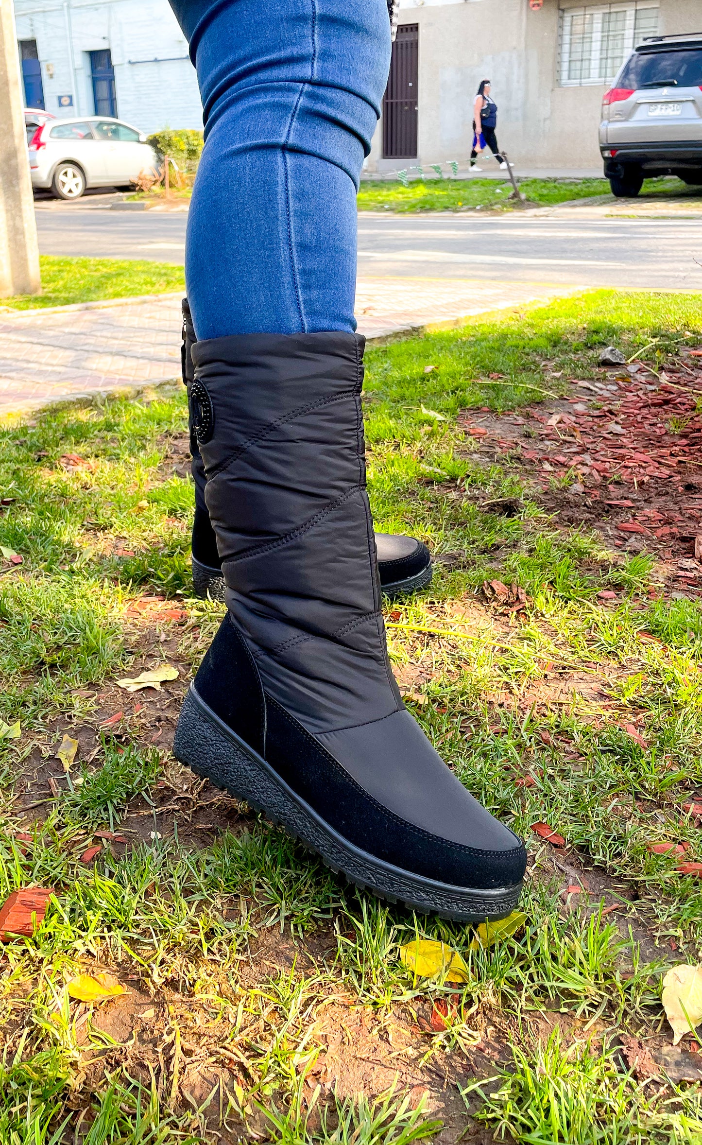 Botines térmicos impermeables negros usados con jeans, capturados en entorno urbano, perfectos para el invierno.