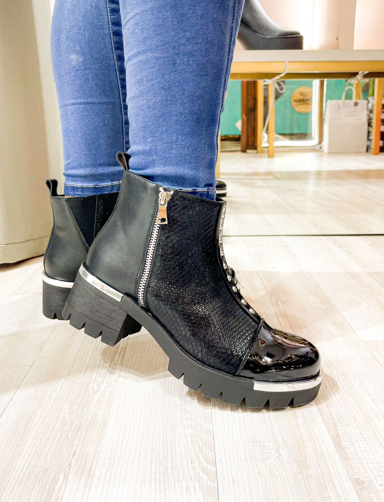 Mujer luciendo el Botín Demi Negro combinado con un look urbano, elegante y con taco cómodo.
