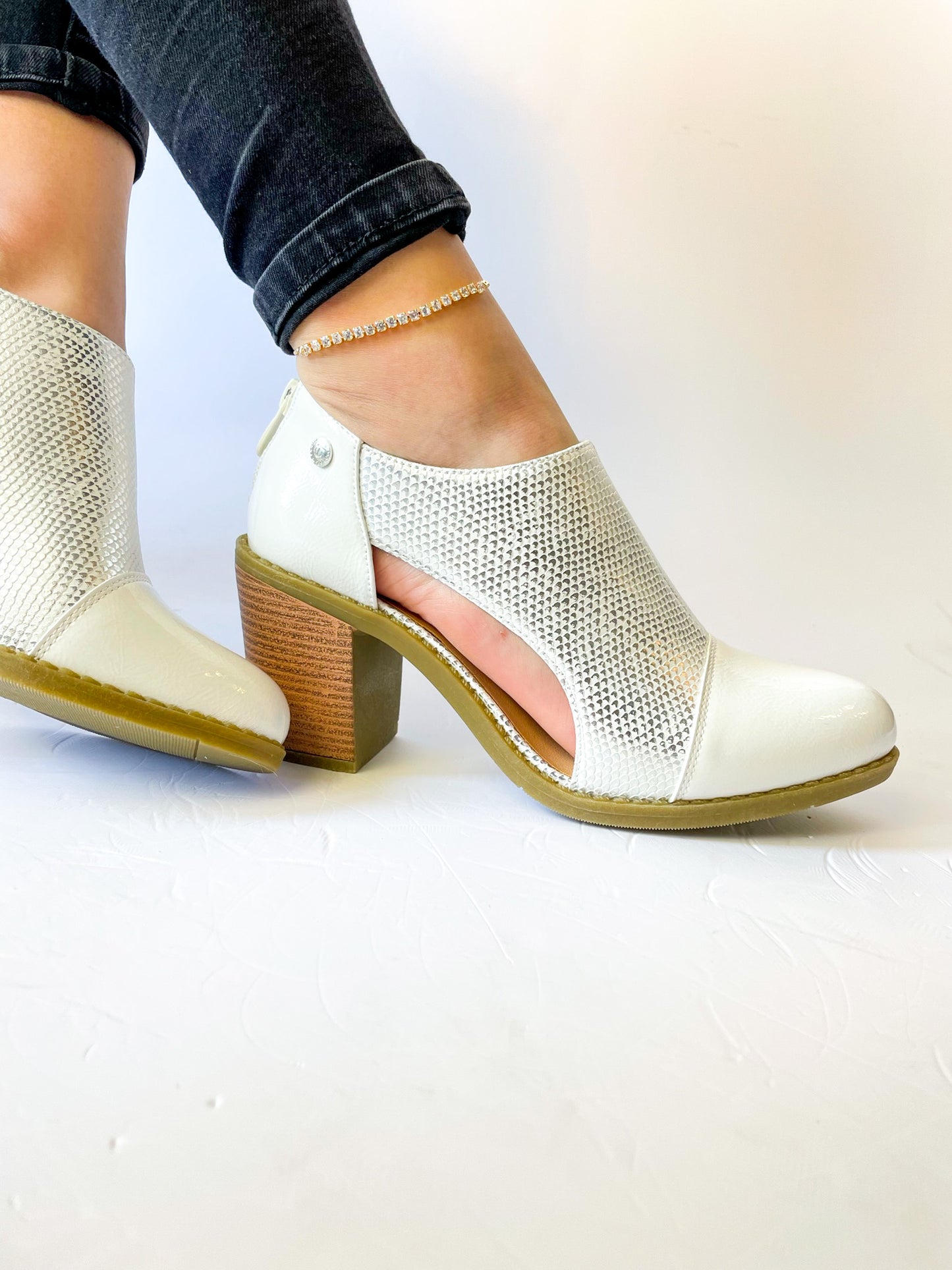 Botín blanco con textura en ecocuero, corte moderno y cierre trasero, ideal para caminar cómoda todo el día.