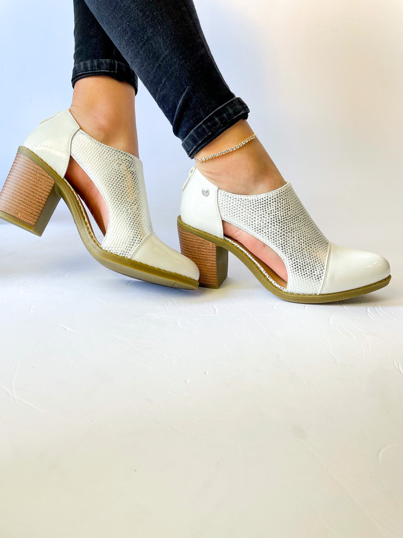 Botín Serena blanco de taco medio con detalles calados y plantilla acolchada, perfecto para outfits urbanos o formales.