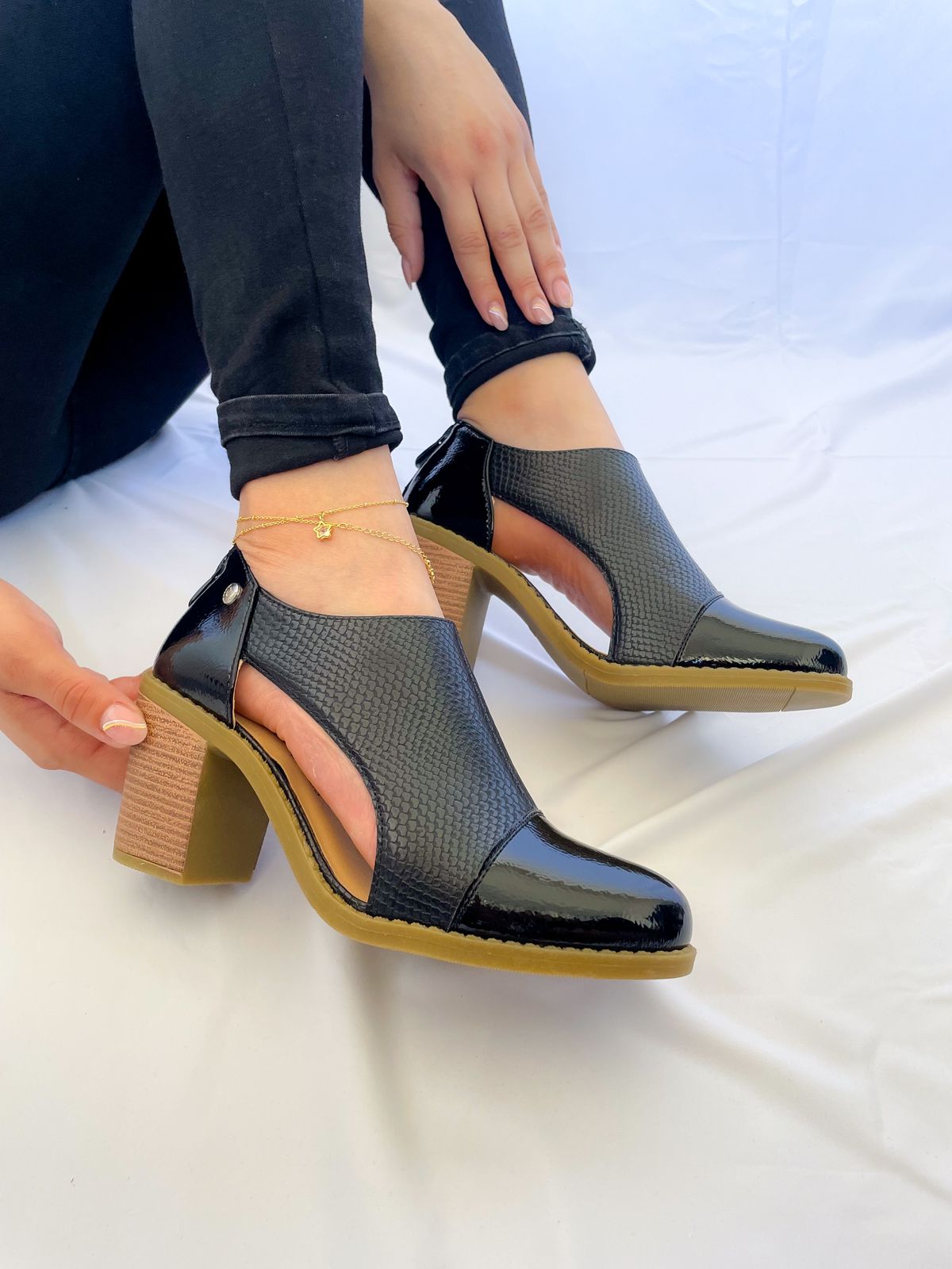 Botín Serena color negro en ecocuero con taco cuadrado de 6 cm, detalle lateral calado y terraplén de goma especial para mayor comodidad.